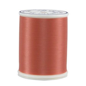 May include: A spool of coral-colored thread.