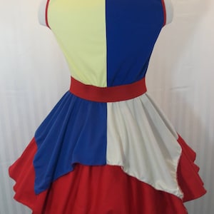 Puede incluir: Un vestido rojo, blanco y azul con un corpi&ntilde;o amarillo y azul. El vestido tiene una falda completa con capas de tela.
