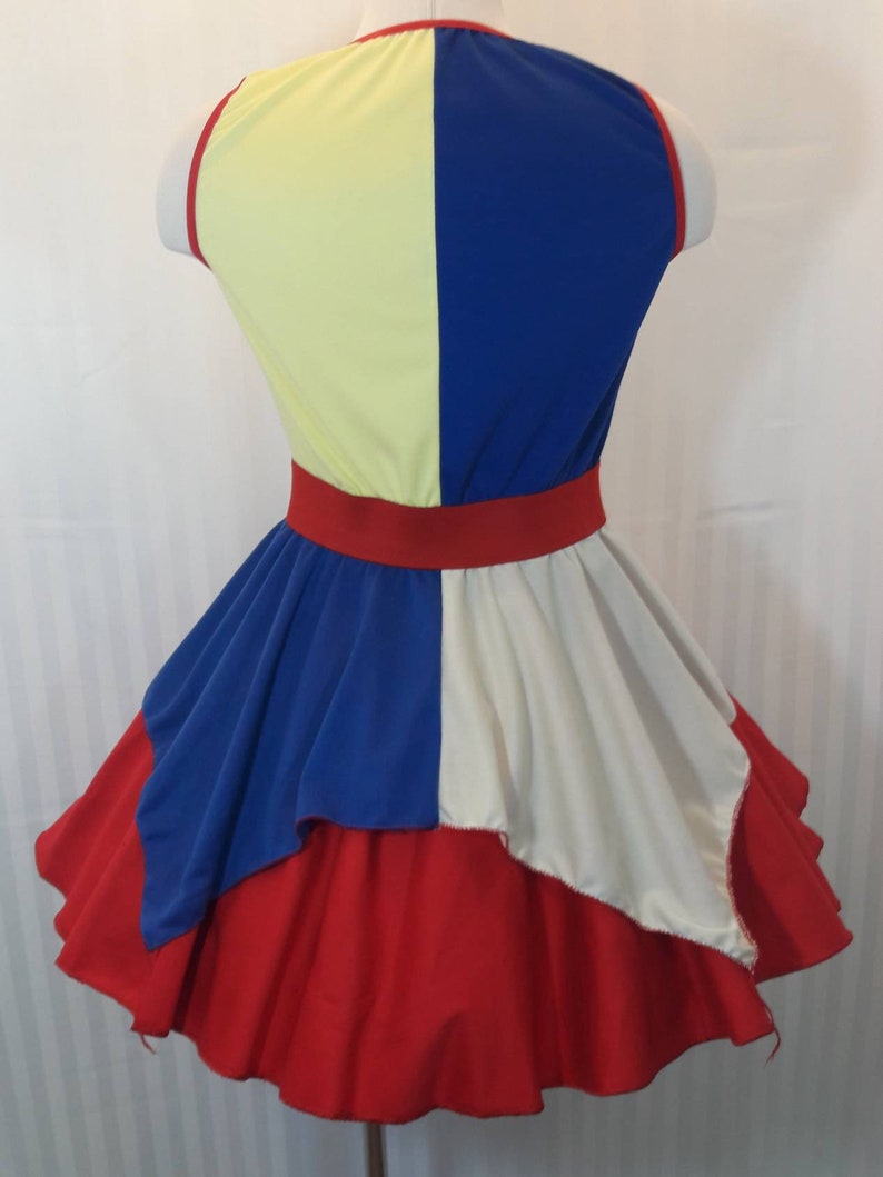 Puede incluir: Un vestido rojo, blanco y azul con un corpi&ntilde;o amarillo y azul. El vestido tiene una falda completa con capas de tela.
