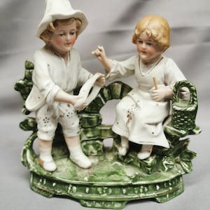 alte Statue, Gruppe von Kindern, die Wolle spinnen. Porzellan, Keks.