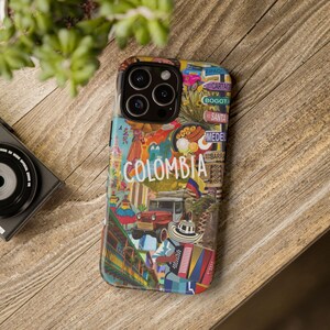 May include: A colourful phone case featuring a collage of images and text relating to Colombia. The case includes a red, white and blue Colombian flag, a yellow taxi and the word "COLOMBIA" in white lettering. The case is designed for an iPhone 13 Pro Max.