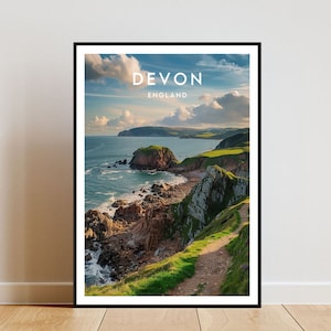 Puede incluir: Un póster panorámico que presenta un paisaje costero en Devon, Inglaterra. El póster muestra una costa rocosa con una ladera verde y un camino que lleva a la cima. El cielo es azul con nubes blancas y el océano es azul oscuro.
