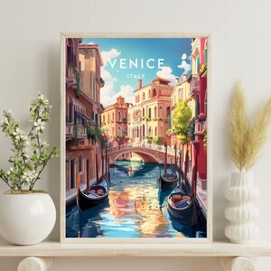 May include: A framed print of a colorful illustration of a canal in Venice, Italy. The print features a view of a narrow canal with gondolas floating on the water. The buildings on either side of the canal are painted in warm colors, and the sky is a bright blue.