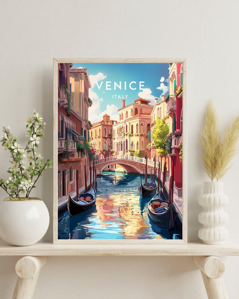 May include: A framed print of a colorful illustration of a canal in Venice, Italy. The print features a view of a narrow canal with gondolas floating on the water. The buildings on either side of the canal are painted in warm colors, and the sky is a bright blue.