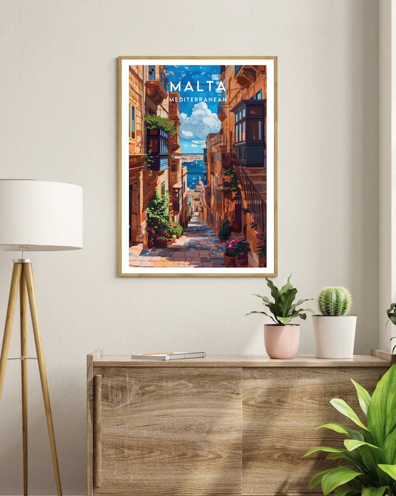May include: A colorful illustration of a narrow street in Malta, with buildings on either side and a view of the Mediterranean Sea in the distance. The text "MALTA MEDITERRANEAN" is at the top of the image.