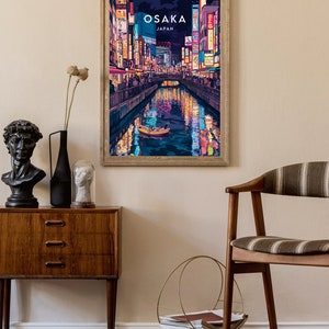May include: A framed poster with a colorful illustration of a canal in Osaka, Japan at night. The poster has the text "OSAKA JAPAN" at the top.