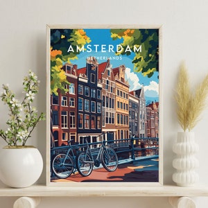 May include: A colorful illustration of Amsterdam, Netherlands, with a canal, bridge, and two bicycles. The text "AMSTERDAM" and "NETHERLANDS" is printed in white on a blue background.