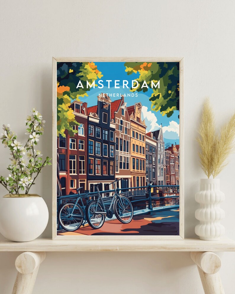 May include: A colorful illustration of Amsterdam, Netherlands, with a canal, bridge, and two bicycles. The text "AMSTERDAM" and "NETHERLANDS" is printed in white on a blue background.