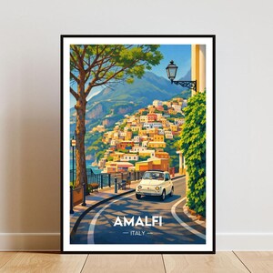 May include: Framed art print of Amalfi, Italy, showing a white car on a winding road. The artwork depicts colourful buildings on a hillside, a tree, and the text "AMALFI - ITALY".