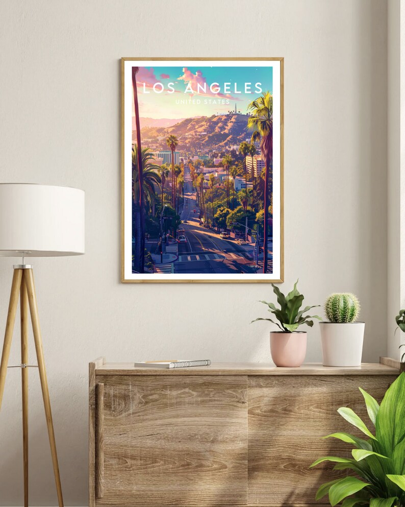 May include: A vintage travel poster with a sunset view of Los Angeles, California. The poster features a road leading up a hill with palm trees lining the sides. The text "LOS ANGELES" and "UNITED STATES" is printed in white at the top of the poster.