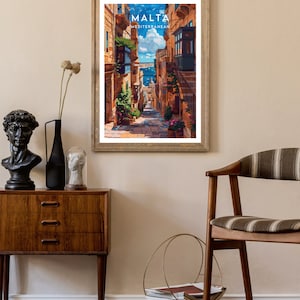 May include: A vintage travel poster featuring a narrow, cobblestone street in Malta. The street is lined with colorful buildings and has a view of the Mediterranean Sea in the distance. The poster has the text "MALTA MEDITERRANEAN" at the top.