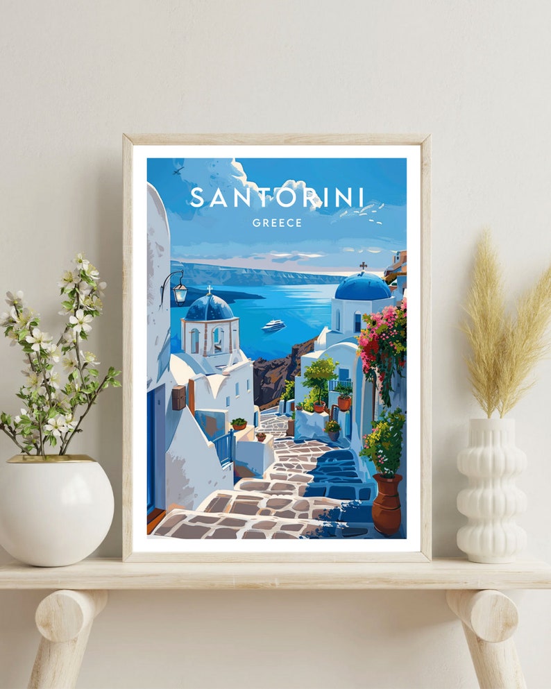 K&ouml;nnte beinhalten: Eine farbenfrohe Illustration einer Stra&szlig;enszene in Santorini, Griechenland. Das Bild zeigt wei&szlig;e Geb&auml;ude mit blauen Akzenten, eine gepflasterte Stra&szlig;e und einen Blick auf die &Auml;g&auml;is. Der Text "SANTORINI GREECE" befindet sich oben im Bild.