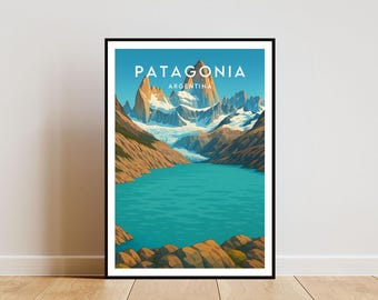Op de afbeelding: Een ingelijste poster met een landschap van Patagonië, Argentinië. De afbeelding toont een turquoise meer, bruine bergen en met sneeuw bedekte toppen onder een blauwe hemel. De titel van de poster luidt "PATAGONIA".