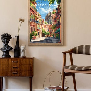May include: A framed poster with a colorful illustration of a street in Barcelona, Spain. The poster features the Sagrada Familia in the background and the text "BARCELONA SPAIN" at the top.