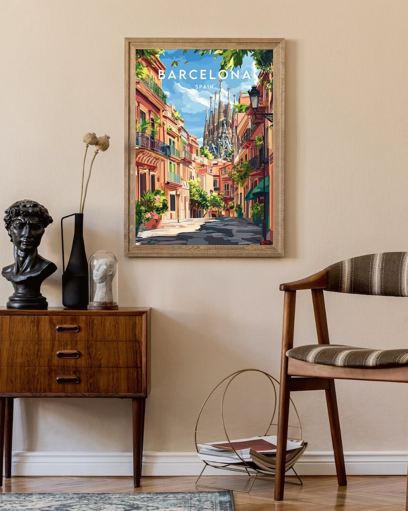 May include: A framed poster with a colorful illustration of a street in Barcelona, Spain. The poster features the Sagrada Familia in the background and the text "BARCELONA SPAIN" at the top.