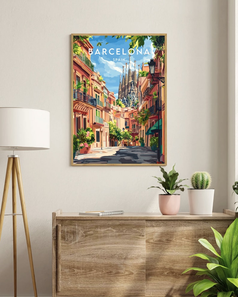 May include: A colorful illustration of a street scene in Barcelona, Spain. The image features a narrow street lined with buildings, with the iconic Sagrada Familia cathedral visible in the background. The text "BARCELONA" and "SPAIN" is displayed at the top of the image.