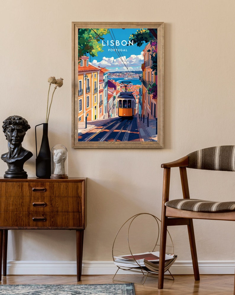 May include: A framed vintage travel poster with a colorful illustration of a yellow tram traveling up a hill in Lisbon, Portugal. The poster has the text "LISBON PORTUGAL" at the top.