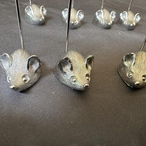 May include: A set of three ceramic mugs with a speckled, matte finish. The mugs are in shades of cream, light gray, and dark gray. Each mug has a simple, minimalist design, perfect for coffee or tea.