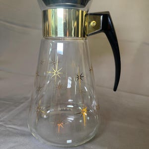 May include: A set of three ceramic mugs with a speckled, matte finish. The mugs are in shades of cream, light gray, and dark gray. Each mug has a simple, minimalist design, perfect for coffee or tea.