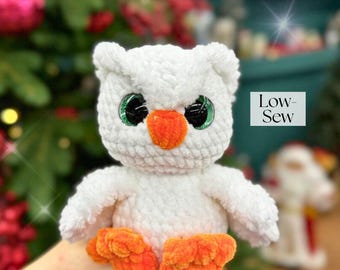 May include: A handmade white owl plush toy with large green eyes, an orange beak, and orange feet. The owl is made of a soft, textured material. The text "Low-Sew" is visible in the image.
