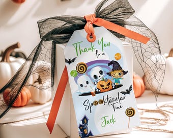 May include: A white gift box with a Halloween-themed tag. The tag features cartoon ghosts, a scarecrow, and a jack-o'-lantern. Text on the tag reads "Thank You for a Spooktacular Time Jack." The box is tied with a black ribbon and orange ribbon.