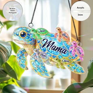 May include: A decorative acrylic turtle ornament with the word "Mama" and the names "Jack", "Liam", "Sarah", "Olivia", and "Henry". The ornament is blue, green, and gold, with a chain for hanging.