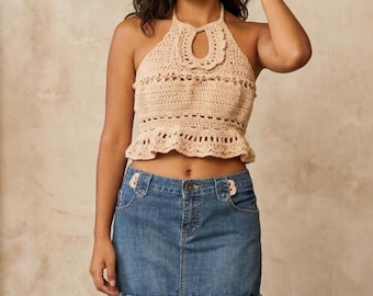 Conjunto de top halter de crochet con abertura frontal y minifalda vaquera con volantes de crochet en el bajo.