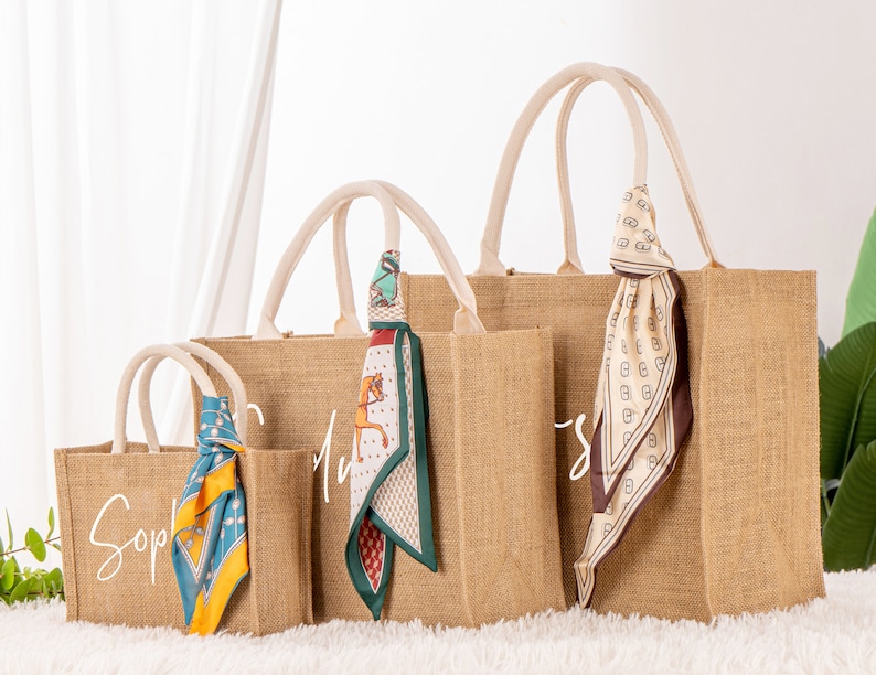 May include: Three brown burlap tote bags with white lettering and colorful patterned scarves. The bags are labeled "Sophie", "My", and "Sweet".