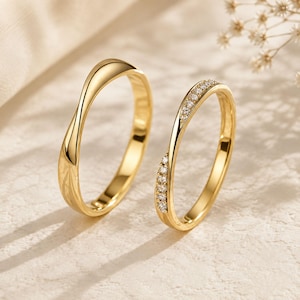 Peut inclure: Deux bagues en or avec une finition lisse et polie. L'une des bagues présente un anneau torsadé simple, tandis que l'autre possède un anneau torsadé assorti orné d'une rangée de petites pierres claires et scintillantes sur la courbe supérieure.