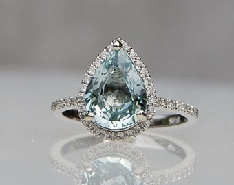 Mint blue green sapphire pear shaped engagement ring in Platinum. Sapphire and diamond halo engagement ring in white gold by Eidelprecious