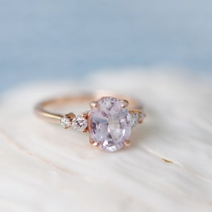 oval lavender peach sapphire engagement ring with round diamonds on the sides. % stone ring, elegant timeless engagement ring in rose gold