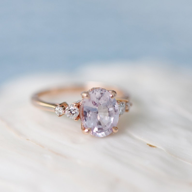 oval lavender peach sapphire engagement ring with round diamonds on the sides. % stone ring, elegant timeless engagement ring in rose gold