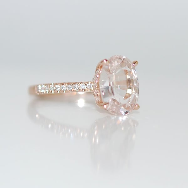 Ovale verlovingsring met witte saffier: roségouden diamanten band