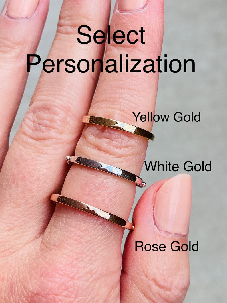 May include: Three gold rings stacked on a finger. The top ring is yellow gold, the middle ring is white gold, and the bottom ring is rose gold. The text "Select Personalization" is at the top of the image.