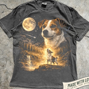 May include: Pepper-colored t-shirt featuring a detailed illustration of a dog under a full moon. The design includes a waterfall, forest, and a smaller dog howling. The text "MADE WITH LOVE BY ANIMAL PARC APPAREL" is visible.