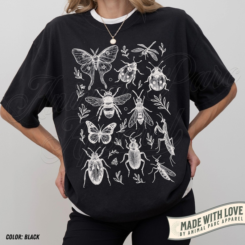 May include: Black t-shirt with a white insect and botanical illustration. The design features a butterfly, bee, dragonfly, ladybug, and other insects. The text "MADE WITH LOVE BY ANIMAL PARC APPAREL" is visible.