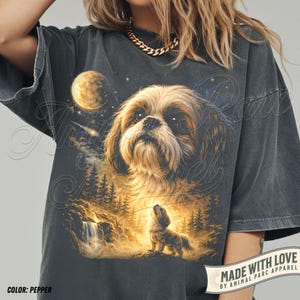 May include: Pepper-colored graphic t-shirt featuring a detailed illustration of a Shih Tzu dog with a celestial background. The design includes a moon, stars, and a smaller dog howling at the moon. The text "MADE WITH LOVE" is visible.
