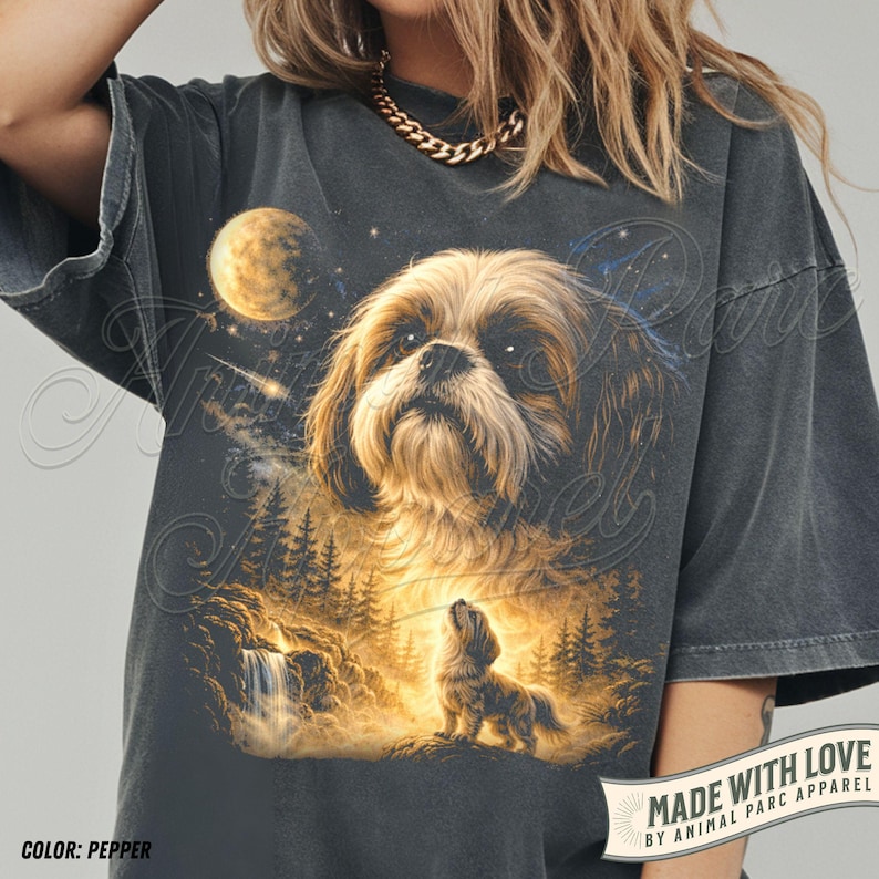 May include: Pepper-colored graphic t-shirt featuring a detailed illustration of a Shih Tzu dog with a celestial background. The design includes a moon, stars, and a smaller dog howling at the moon. The text "MADE WITH LOVE" is visible.