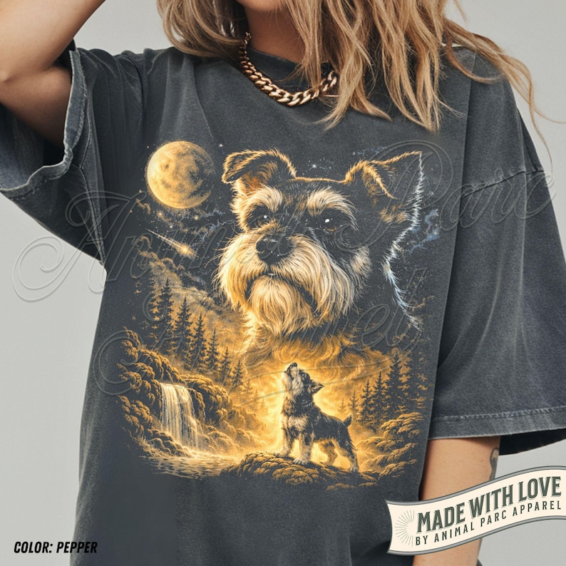 May include: Pepper-coloured t-shirt with a detailed illustration of a Schnauzer dog under a full moon, with a smaller dog howling in a forest scene. The text "MADE WITH LOVE" and "COLOR: PEPPER" are also visible.