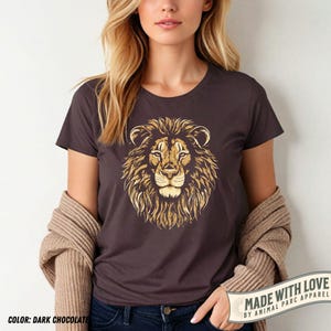 May include: Dark chocolate-colored t-shirt featuring a detailed golden lion's head graphic. The shirt has a crew neck and short sleeves. The text "MADE WITH LOVE" and "COLOR: DARK CHOCOLATE" are visible.