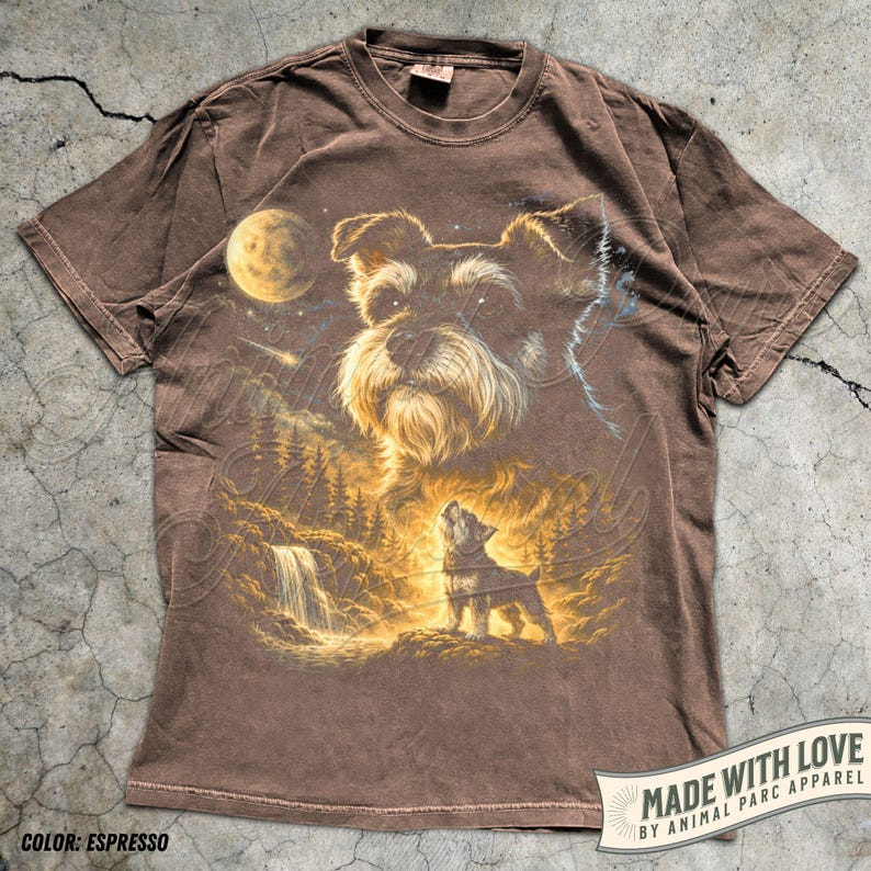 May include: Espresso-coloured t-shirt with a detailed graphic of a Schnauzer dog howling at the moon, set against a waterfall and forest backdrop. The shirt includes the text "MADE WITH LOVE BY ANIMAL PARC APPAREL" and "COLOR: ESPRESSO".