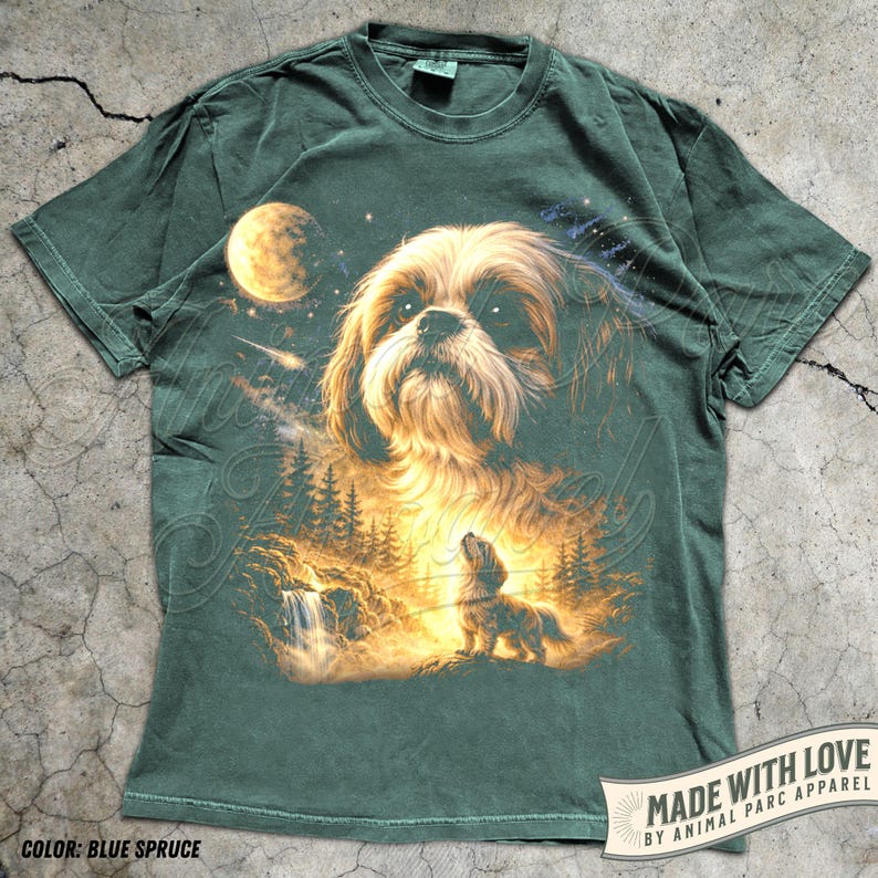 May include: Blue spruce-colored t-shirt featuring a detailed illustration of a dog with a celestial background. The design includes a moon, stars, and a smaller dog in a forest scene. The text "MADE WITH LOVE BY ANIMAL PARC APPAREL" is visible.