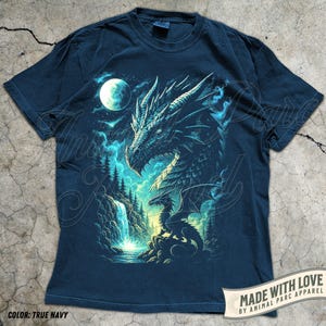 May include: True navy blue t-shirt featuring a detailed dragon illustration with a waterfall, moon, and forest scene. The dragon is depicted in shades of blue and teal. The text "MADE WITH LOVE BY ANIMAL PARC APPAREL" is visible.