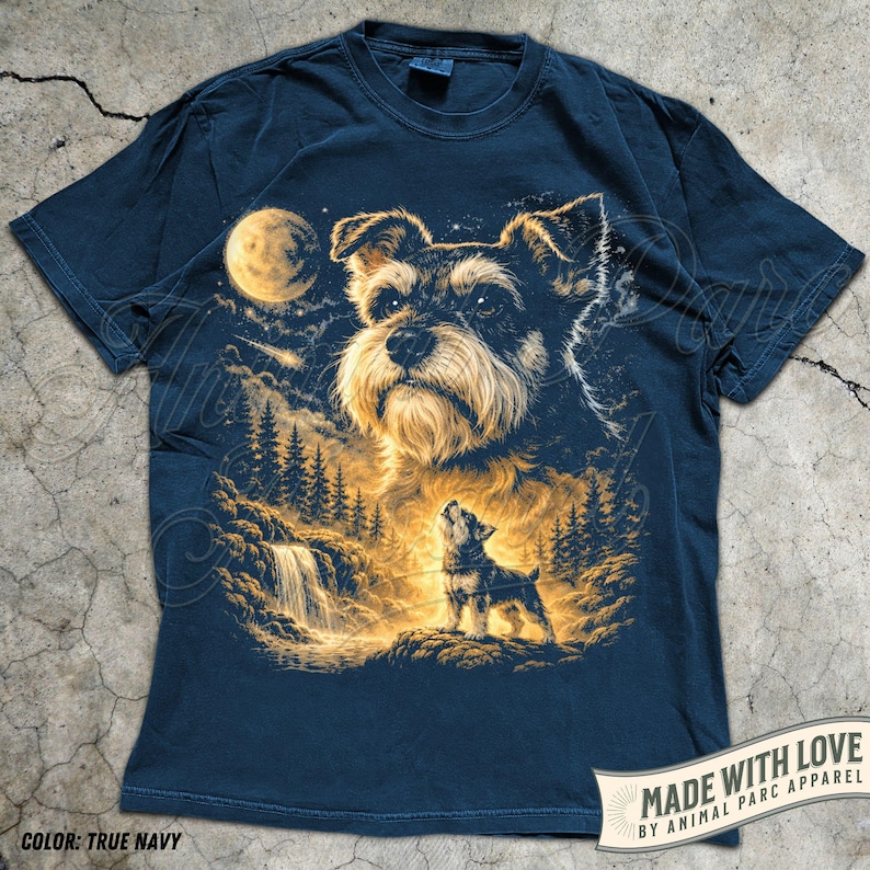 May include: Navy blue t-shirt with a detailed illustration of a dog, a full moon, a waterfall, and a forest scene. The design includes a large dog's face and a smaller dog howling at the moon. The text "MADE WITH LOVE BY ANIMAL PARC APPAREL" is also visible.