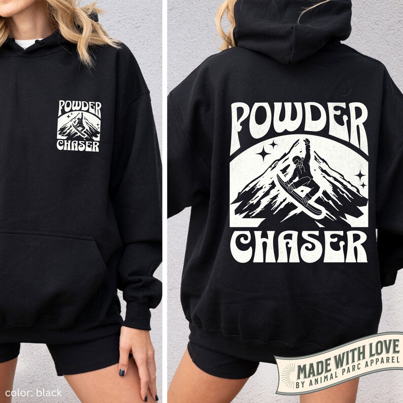 May include: Black hoodie with a front pocket and hood. The front displays "POWDER CHASER" above a mountain graphic. The back of the hoodie has a larger version of the same design, with a skier on a mountain. The hoodie is black.
