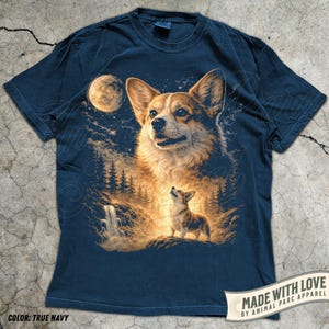 May include: Navy blue t-shirt featuring a detailed illustration of a Corgi dog with a forest and waterfall scene under a full moon. The shirt includes the text "MADE WITH LOVE BY ANIMAL PARC APPAREL" and the color is "TRUE NAVY".