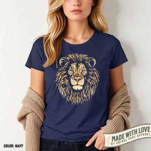 May include: Navy blue t-shirt featuring a detailed golden lion's head graphic. The design includes the text "MADE WITH LOVE BY ANIMAL PARC APPAREL" on a banner. The shirt's color is navy, as indicated by the text "COLOR: NAVY".