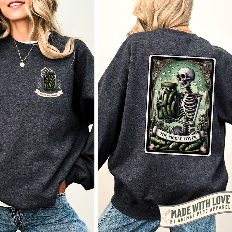 May include: Dark gray sweatshirt with a front chest graphic of a jar of pickles with the words 'THE PICKLE LOVER' on a banner. The back of the sweatshirt features a skeleton holding a jar of pickles with the same banner. The sweatshirt has a 'MADE WITH LOVE' tag.