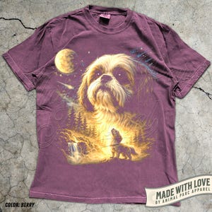 May include: Berry-colored t-shirt featuring a detailed illustration of a Shih Tzu dog with a celestial background. The design includes a moon, stars, and a forest scene with a waterfall. The text "MADE WITH LOVE" and "COLOR: BERRY" are also visible.