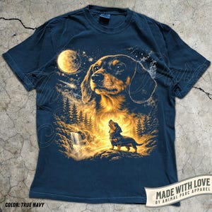 May include: True navy blue t-shirt featuring a detailed illustration of a dachshund dog under a full moon, with a forest and waterfall scene. The design includes the text "MADE WITH LOVE BY ANIMAL PARC APPAREL" and "COLOR: TRUE NAVY".